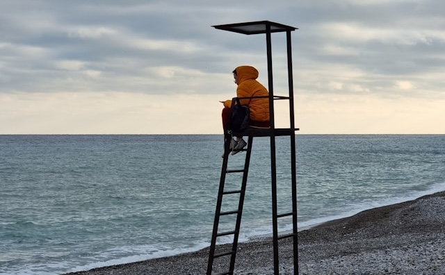 person sitting alone watching the sea